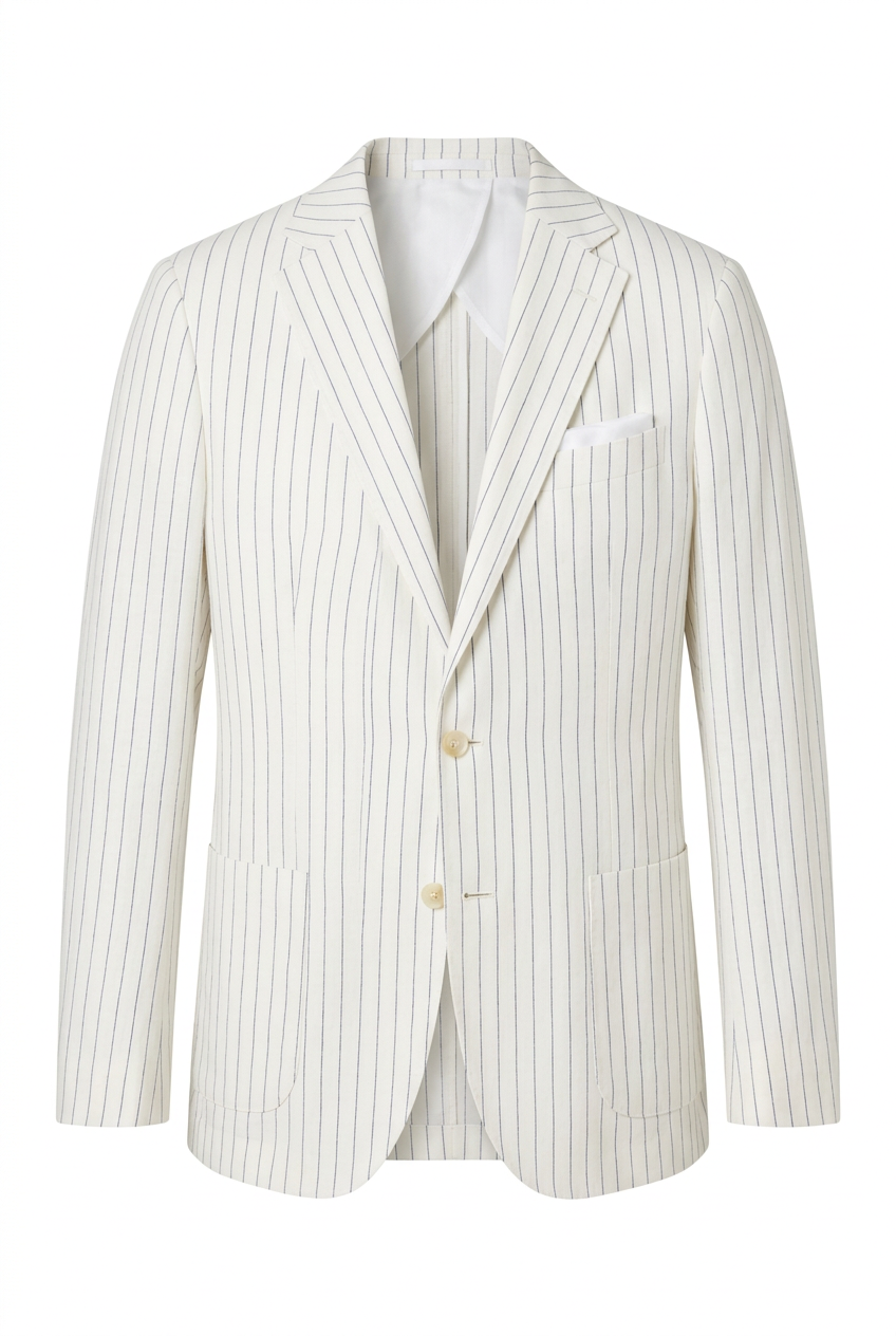 A man wearing a light beige pinstripe suit, white t-shirt, and sunglasses walks on a wooden yacht deck next to the blue sea.
