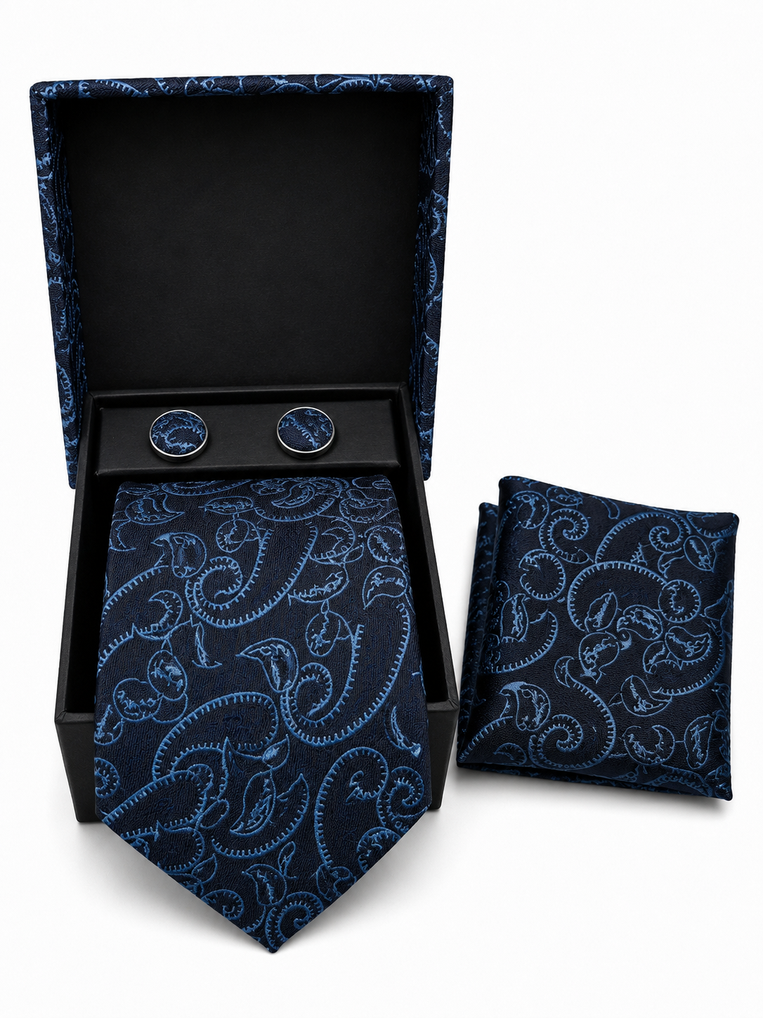 A men's necktie and matching pocket square set with round cufflinks, displayed in an open black presentation box on a white background. The fabric features a light blue paisley pattern on a dark navy base.