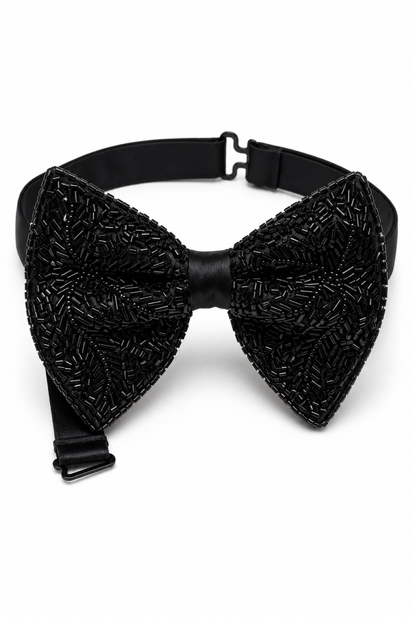 A tuxedo black bow tie embellished with intricate beaded patterns, featuring a matching black adjustable strap with metal buckles, is shown against a plain white background.