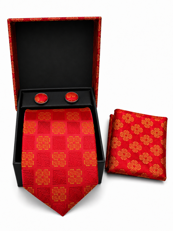 A red and gold men's necktie and matching pocket square set displayed in an open black gift box with two matching red cufflinks, photographed on a white background.