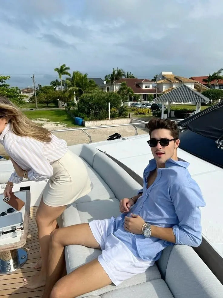 Two people on a boat with a residential area in the background