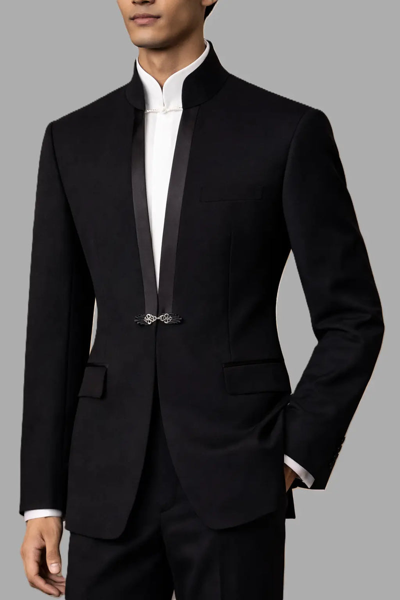 Man wearing a black suit with a white shirt on a gray background